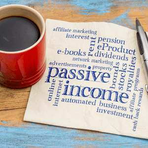 Passive income concept with keywords on napkin, coffee cup, and pen; affiliate marketing, e-books, dividends, automated investment.
