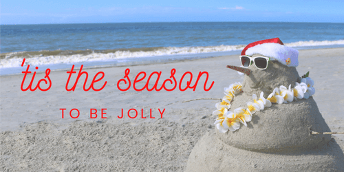 Beach-themed Christmas sandman with sunglasses, Santa hat, and floral lei, with "Tis the season to be jolly" text.